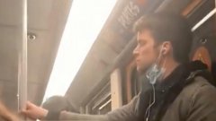 Un homme portant un masque de protection répand sa salive sur la barre du métro